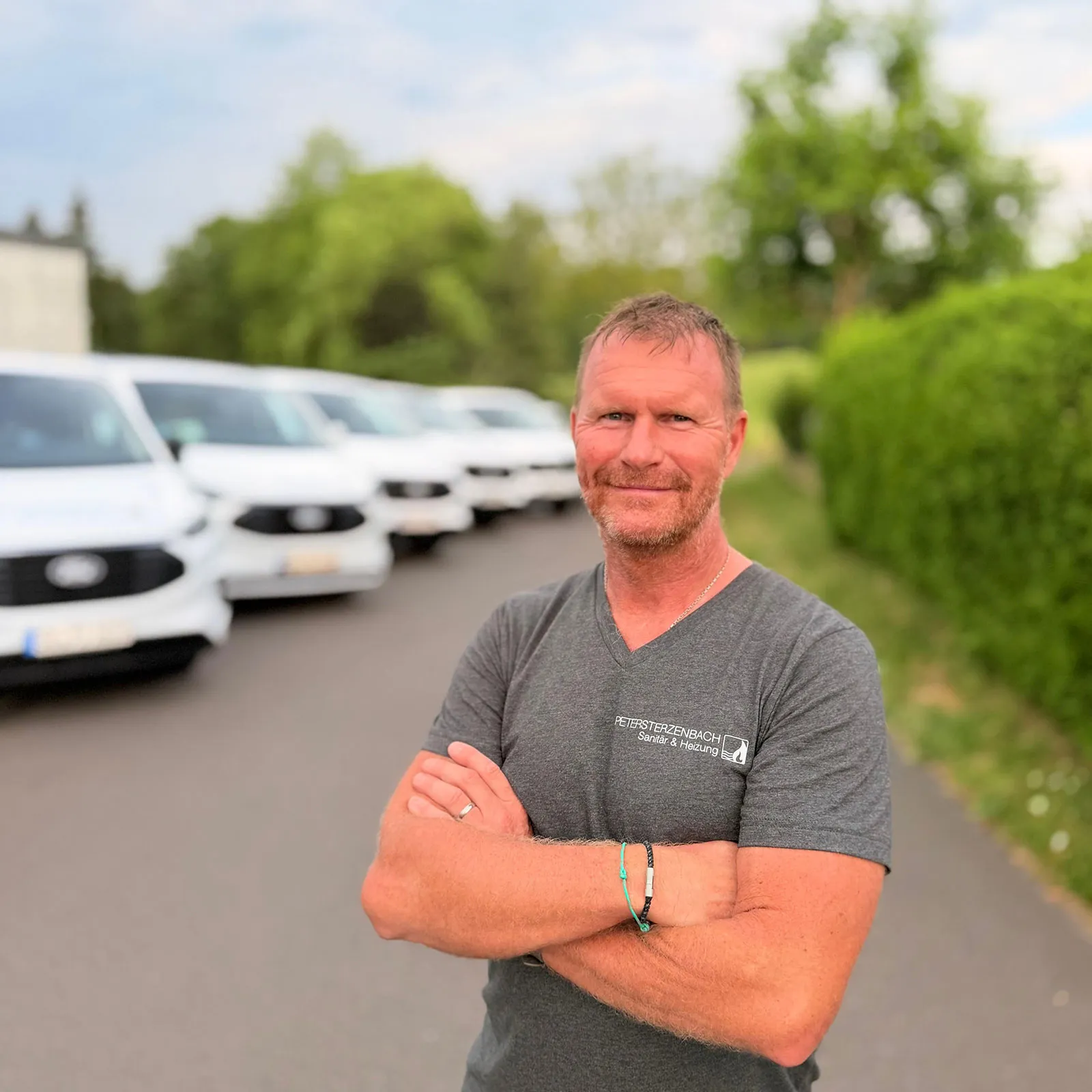 Peter Sterzenbach vor den Fahrzeugen des Betriebs
